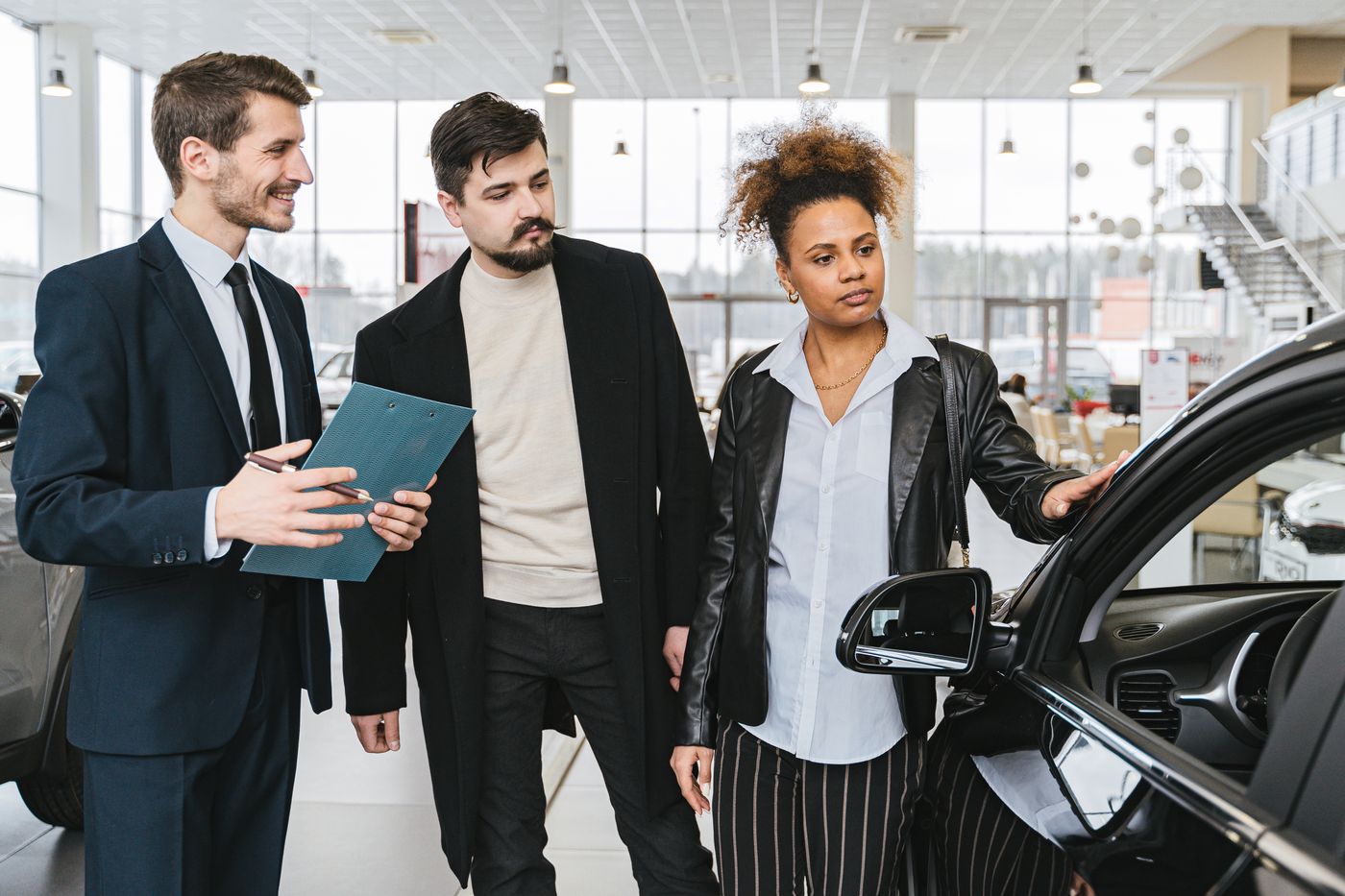 Customers discussing a car with a showroom adviser